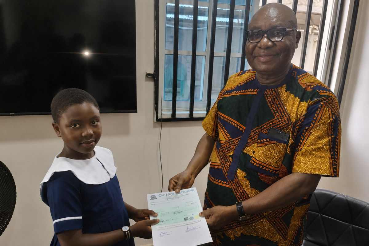 The president of the ovu foundation presenting a cheque to a student for her scholarship